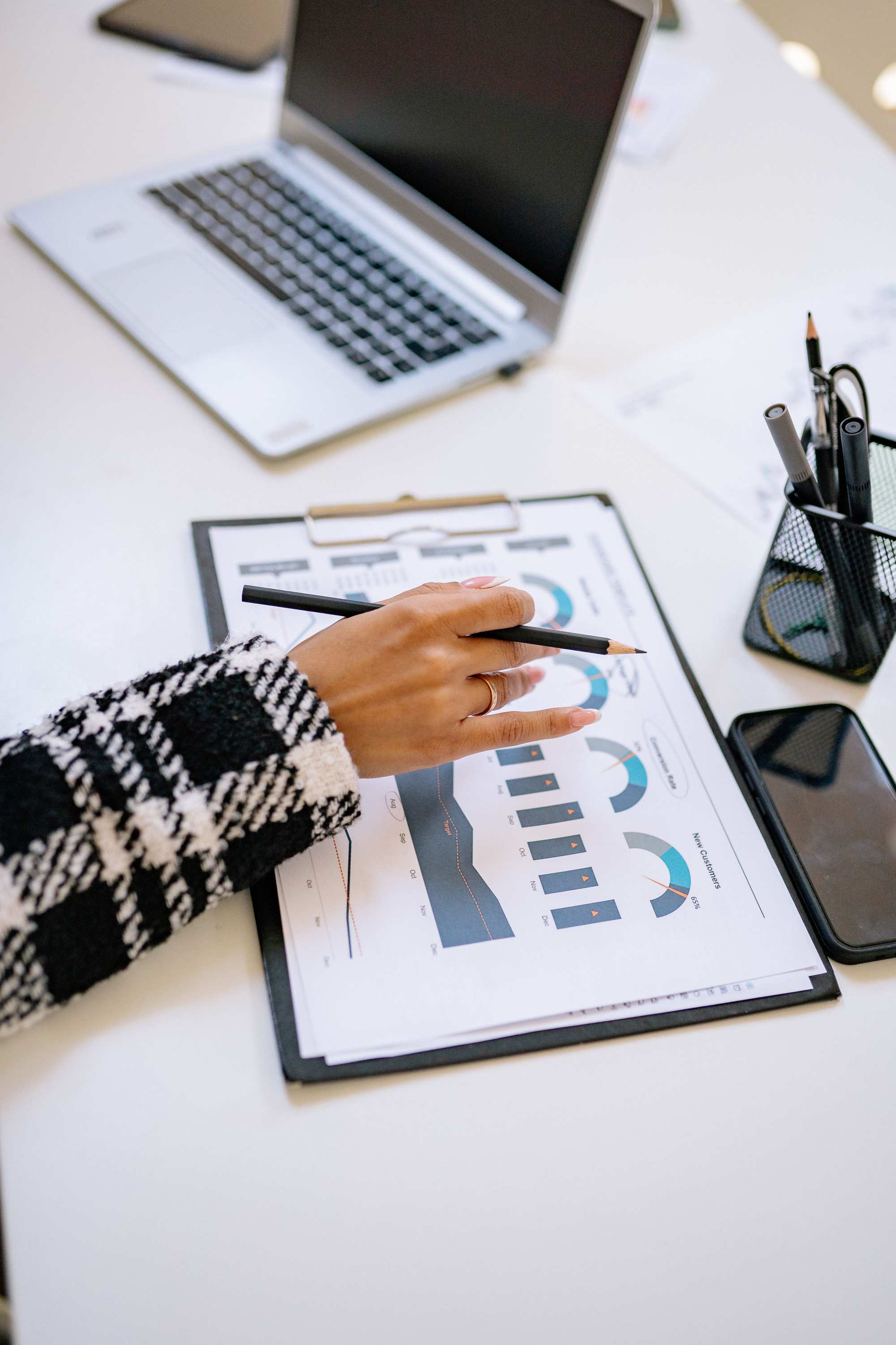 Hände an einem Laptop mit Finanzdaten und Charts